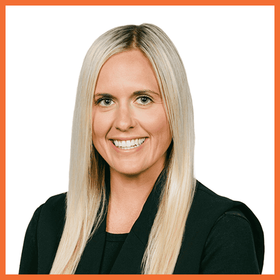 Rachel_Portela_Outline - metroConnections Head-and-shoulders portrait of a smiling blonde woman in a black blazer against a white background.