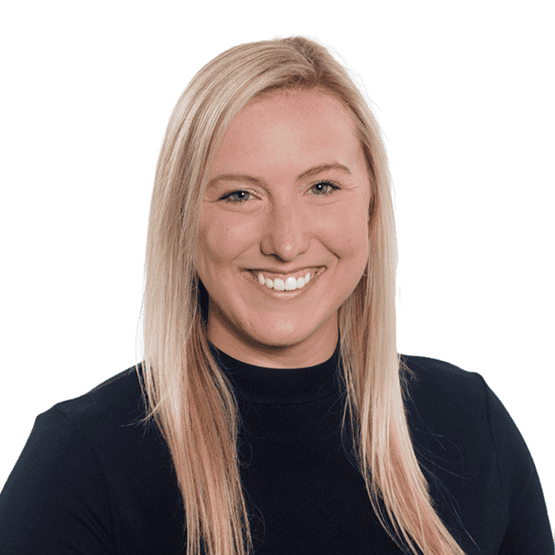 Smiling blonde woman wearing a black top, portrait against a white background.