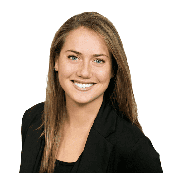 Professional headshot of a smiling woman in a black blazer against a white background, looking at the camera and slightly angled.