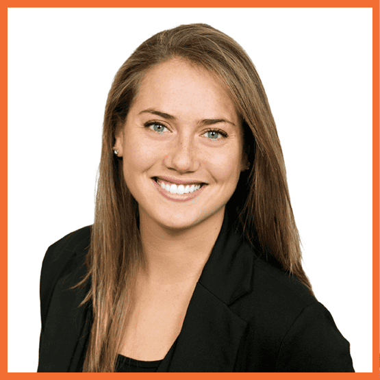 Smiling professional portrait of a woman in a black blazer against a white background.